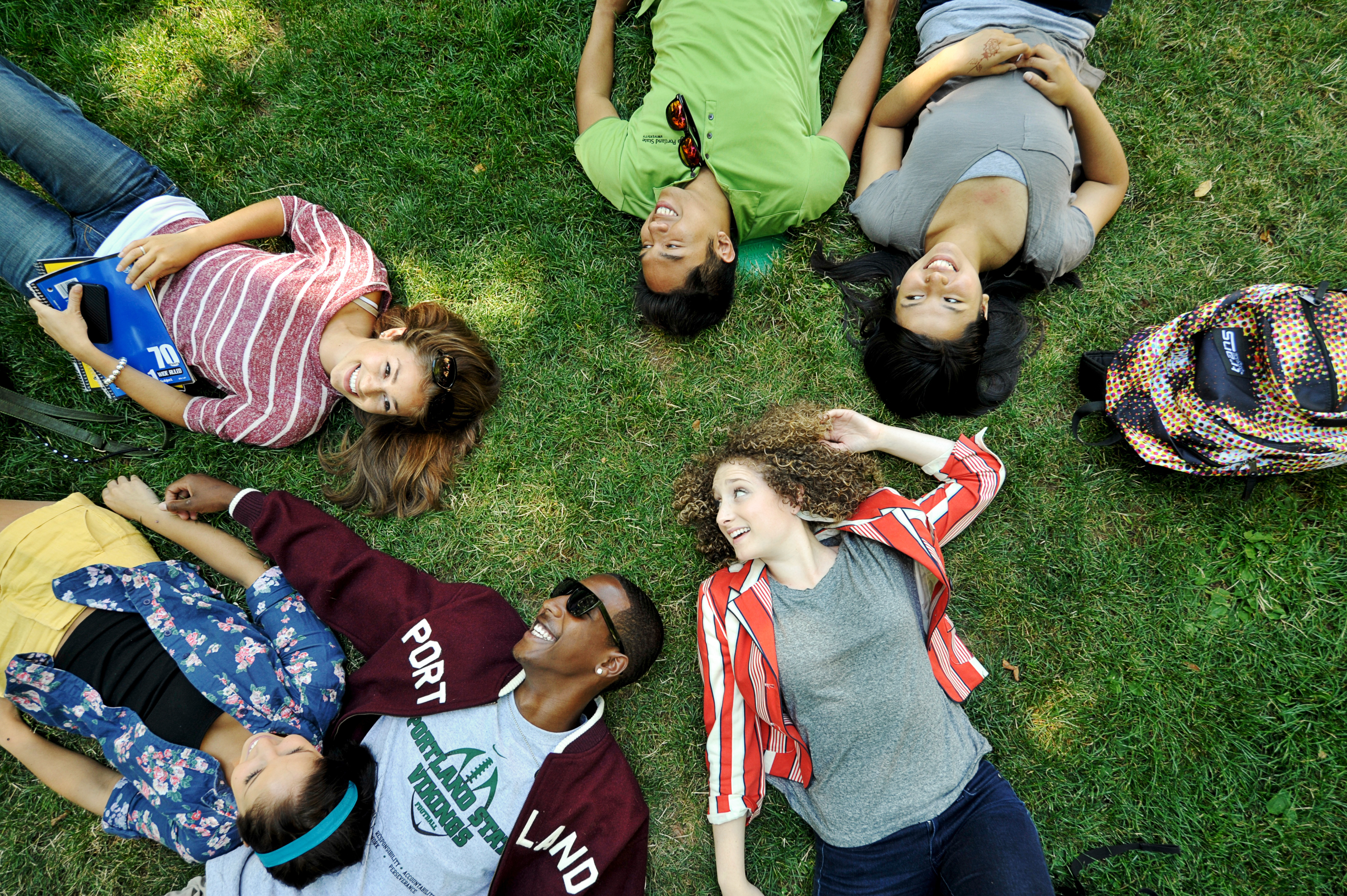 Diverse group of PSU students laying on the grass in the PSU Park Blocks.