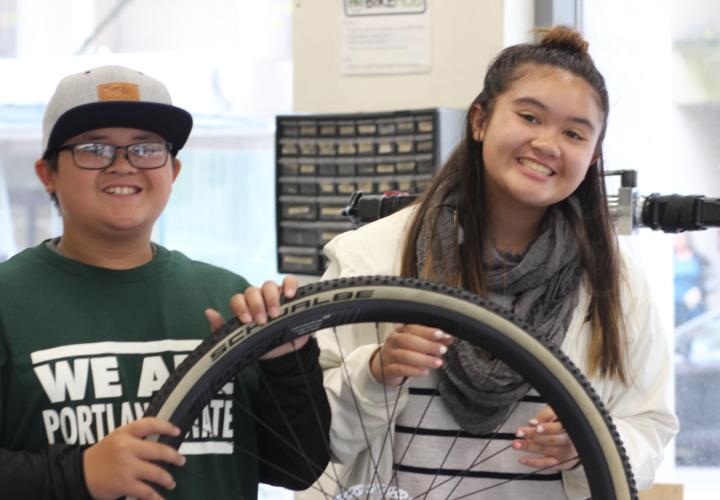 Children of PSU students holding a bike tire.